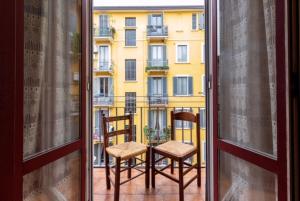 an open window with two chairs and a building at Alessia's Flat- Loreto 2 in Milan