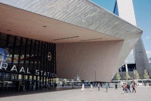 un grande edificio con persone che camminano davanti di TamTam Studio a Rotterdam