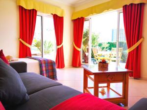アルヴォルにあるAlvor Vila da Praia Pool & Garden Viewのリビングルーム(赤いカーテン、ソファ付)