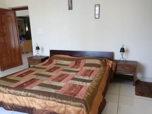 um quarto com uma cama e duas mesas de cabeceira em Robin Woods Homestay em Sakleshpur