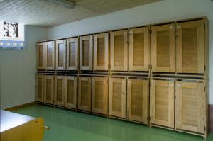 a row of wooden lockers in a room at Crucesinn Albergue in Padrón