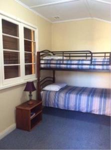 a bedroom with two bunk beds and a table with a lamp at Wylie Stays in Wyalkatchem