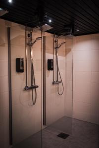 La salle de bains est pourvue d'une douche avec une porte en verre. dans l'établissement Hotel Aakenus, à Rovaniemi