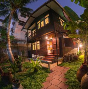 a wooden house with a bench in front of it at Yesterday Sathon in Bangkok