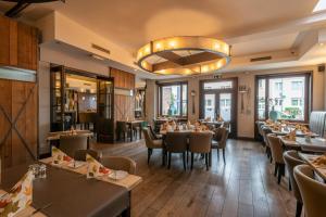 a restaurant with tables and chairs and a chandelier at Hotel Zur Krone in Meerbusch