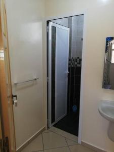 Łazienka z prysznicem i szklanymi drzwiami w obiekcie Résidence Elgzira w mieście Mirleft