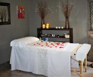 une table avec un chiffon de table blanc et des roses dans l'établissement Gala Gala Eco Resort, à Ponta do Ouro
