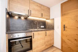 a kitchen with a sink and a stove at Appartements Schrambacherhof in Achenkirch