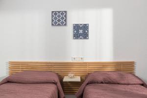 a bedroom with two beds and two windows at Apartaments Els Llorers in Lloret de Mar