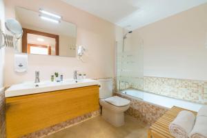 a bathroom with a sink and a toilet and a tub at Apartaments Els Llorers in Lloret de Mar