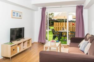 a living room with a couch and a tv at Apartaments Els Llorers in Lloret de Mar