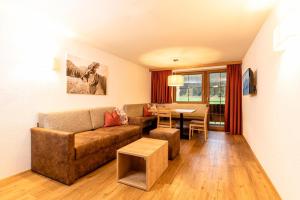 ein Wohnzimmer mit einem Sofa und einem Tisch in der Unterkunft Appartements Schrambacherhof in Achenkirch