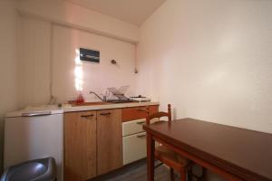 una piccola cucina con tavolo e frigorifero di Petit T1 à proximité des thermes ad Aix-les-Bains