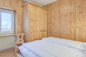 a bedroom with wood paneled walls and a bed at Cesa Ciampac 5 in Alba di Canazei
