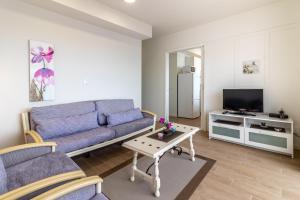 sala de estar con sofá azul y TV en Flatguest Danubio + Sea view + Pool + Beach, en Mogán