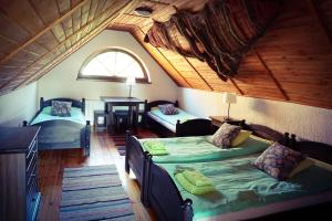 a attic room with two beds and a window at Mazurska Zagroda in Rydzewo
