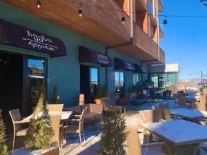 a restaurant with tables and chairs in front of a building at Bakuriani the Valley 115 - 202 in Bakuriani