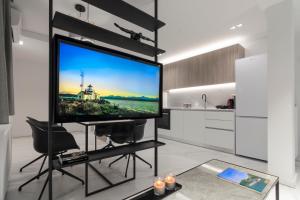 duży telewizor z płaskim ekranem na stojaku w salonie w obiekcie Heritage Boutique Apartments w Atenach