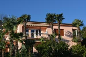 a building with palm trees in front of it at Apartment Valentina in Opatija