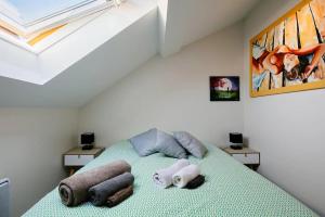 1 dormitorio con 1 cama con toallas en le cocon voironnais, en Rives