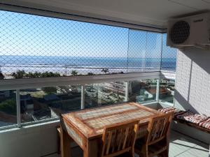 d'une table et de chaises sur un balcon avec vue sur l'océan. dans l'établissement Apartamento em frente a praia, à Praia Grande