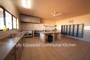 a kitchen with a sink and a ceiling fan at Radeka Downunder Underground Motel in Coober Pedy