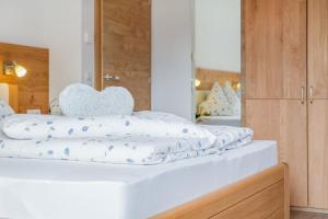 a bed with white sheets and a heart pillow on it at Hofschenke Pfeiftal - Bergblick in San Martino