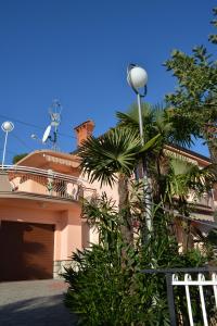 a palm tree in front of a house at Apartment Valentina in Opatija