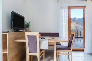 a dining room with a table with a television on it at Hofschenke Pfeiftal - Bergblick in San Martino