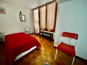Apartment La Terrazza في أوريو آل سيريو: غرفة نوم بسرير احمر وكرسي احمر