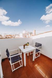 シウタデリャにあるPetit Hotel 5 Farsの白いテーブルと椅子、景色を望むバルコニー