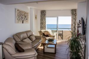 フエンヒロラにあるBeachfront apartment in Fuengirola with sea viewsのリビングルーム(ソファ、椅子付)が備わります。