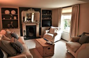 - un salon avec deux chaises et une cheminée dans l'établissement Country chic in unique English village, à Nun Monkton