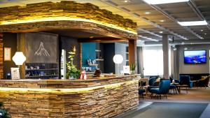 a bar in a lobby with a stone wall at Hotel Ambassador Zermatt in Zermatt