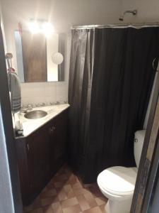 a bathroom with a black shower curtain and a toilet at Hermoso departamento para viajeros in San Fernando +13 photos