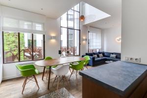 巴黎的住宿－LOFT A BASTILLE，厨房以及带桌子和绿色椅子的客厅。