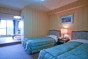 ein Hotelzimmer mit 2 Betten und einem Fenster in der Unterkunft ホテル グリーンヒル 大多喜 in Ōtaki