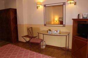 Zimmer mit einem Tisch, einem Spiegel und einem Stuhl in der Unterkunft Hotel Semifonte in Poggibonsi
