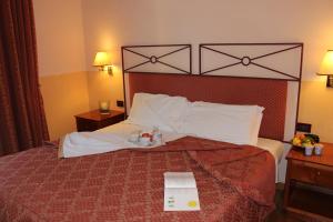 ein Hotelzimmer mit einem Bett mit einem Buch darauf in der Unterkunft Hotel Semifonte in Poggibonsi