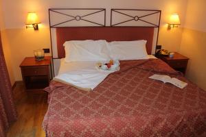 ein Schlafzimmer mit einem großen Bett mit zwei Nachttischen in der Unterkunft Hotel Semifonte in Poggibonsi