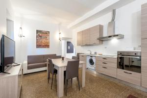 eine Küche und ein Wohnzimmer mit einem Tisch und Stühlen in der Unterkunft Tour de Rome in Rom