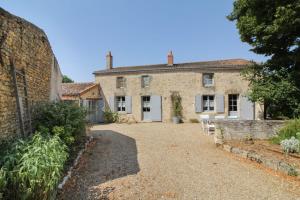 an old stone house with a driveway in front of it at La Jariette in Airvault