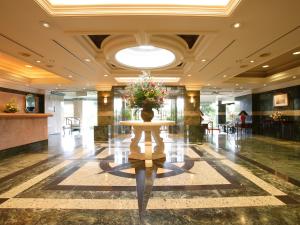 a lobby with a table with a vase of flowers on it at ホテル グリーンヒル 大多喜 in Ōtaki