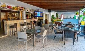 un restaurante con mesas y sillas y un bar en A Maos Hotel Apartments, en Ayia Napa