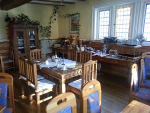 a dining room with a wooden table and chairs at Hotel Blaues Haus in Otterberg