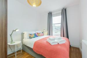 ロンドンにあるWelcomeStay Clapham Junction 2 Bedroom Apartmentのベッドルーム1室(タオル付)