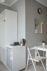 アストラハンにあるGagarin Mini-Hotelのキッチン(白い冷蔵庫、テーブル、椅子付)