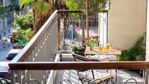 un tavolo e sedie di legno su un balcone di Ruby a Tel Aviv