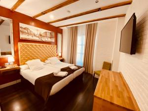 pokój hotelowy z dużym łóżkiem i telewizorem w obiekcie Hotel Palace Sevilla w Sewilli