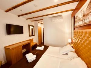 pokój hotelowy z łóżkiem i telewizorem z płaskim ekranem w obiekcie Hotel Palace Sevilla w Sewilli